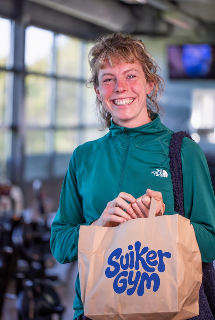 Een deelneemster verlaat de gym met haar ontbijt in een tas van Suikergym